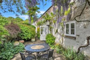a patio with a table and chairs in front of a building at Finest Retreats - The Pottage in Yaxley