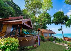 a house next to the ocean with a yard at Ting Rai Bay Resort in Ko Jum