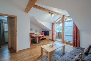 a living room with a couch and a table at Hotel MY Kramerwirt in Geiersthal