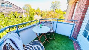 ein kleiner Tisch und zwei Stühle auf einem Balkon in der Unterkunft Staytopus Pension - Heidepark, Kartbahn, Sauna ink, Garden, BBQ in Schneverdingen