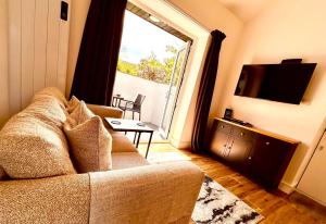 a living room with a couch and a large window at Hideaway Suite in Ambleside