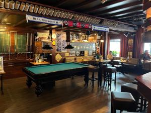 a bar with a pool table in the middle of a room at Hotel Café Restaurant "De Kroon", inclusief ontbijt in Wissenkerke