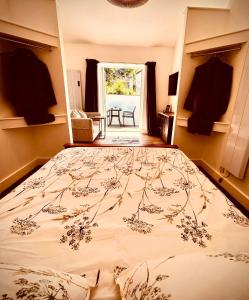 a large bed in a room with a window at Hideaway Suite in Ambleside