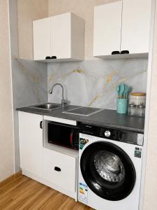 a kitchen with a washing machine and a sink at Evergreen Hotel in Ulaanbaatar