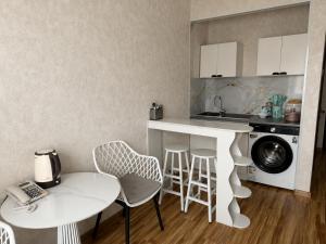 a kitchen with a counter and a table and chairs at Evergreen Hotel in Ulaanbaatar