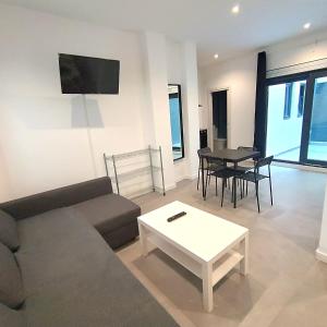 a living room with a couch and a table at Apartamentos ATARAZANAS in Málaga