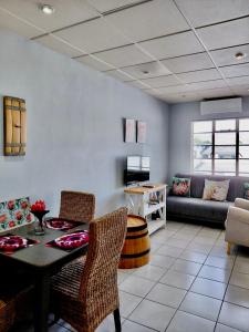 a living room with a table and chairs and a couch at The Protea & Vine - Paarl - Self Catering Apartment in Paarl