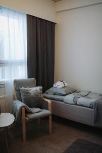 a bedroom with a bed and a chair and a window at Eurajoen opisto in Eurajoki