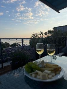a plate of cheese and two glasses of wine at Chez Yoyo Mobil-home tout confort pour des vacances inoubliables in Saint-Raphaël