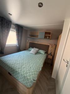a bedroom with a bed in a small room at Chez Yoyo Mobil-home tout confort pour des vacances inoubliables in Saint-Raphaël
