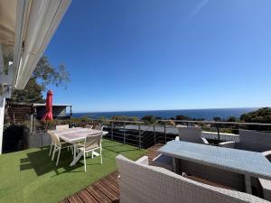 a patio with a table and chairs and the ocean at Chez Yoyo Mobil-home tout confort pour des vacances inoubliables in Saint-Raphaël