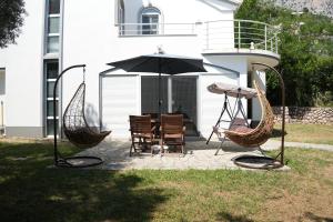 a patio with a table and chairs and an umbrella at Vila Brca in Brca +32 photos