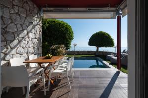 a patio with a table and chairs next to a swimming pool at Tyros Boutique Houses Villas in Tyros
