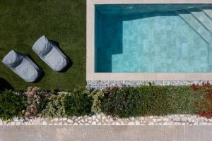 an overhead view of a swimming pool with two chairs at Tyros Boutique Houses Villas in Tyros