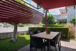 a wooden table and chairs under a red umbrella at Tyros Boutique Houses Villas in Tyros