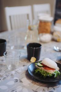 a sandwich on a black plate on a table at Eurajoen opisto in Eurajoki
