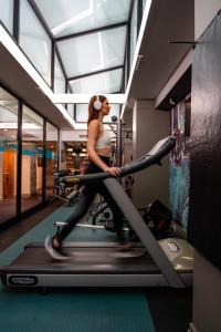 a woman running on a treadmill in a gym at Radisson Hotel Cape Town Foreshore in Cape Town
