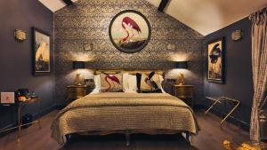 ein Schlafzimmer mit einem Bett und einer tapezierten Wand. in der Unterkunft Black Rabbit Croston Boutique Hotel & Restaurant in Croston