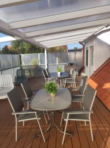 a patio with tables and chairs on a deck at Hotel am Gutspark Berthold Andre und Ursula Prager GbR in Leipzig