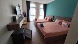 a room with two beds and a flat screen tv at ADRi in Phú Quốc