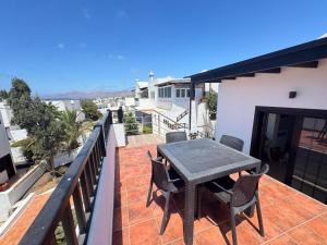 a patio with a table and chairs on a balcony at Casa Solano in Tías