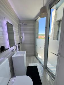 a bathroom with a white toilet and a window at St.Barth Apartments in Šibenik