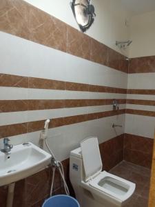 a bathroom with a toilet and a sink at Mega Grand Rooms in Narasaraopet