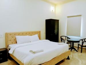 a bedroom with a bed and a table and a chair at Mega Grand Rooms in Narasaraopet