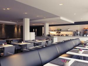 a restaurant with tables and chairs and a kitchen at Mercure Hotel Nijmegen Centre in Nijmegen