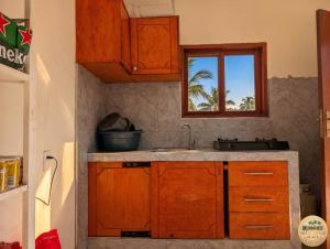 a kitchen with wooden cabinets and a sink at Nhacuene's place in Vilanculos