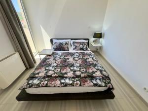 a bedroom with a bed with a floral bedspread at St.Barth Apartments in Šibenik