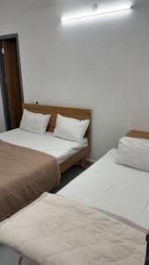 two beds sitting next to each other in a room at Hotel Aura Avenue in Bathinda