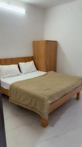 a large bed with a wooden headboard in a bedroom at Hotel Aura Avenue in Bathinda