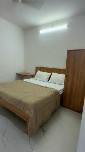 a bed with a wooden headboard in a room at Hotel Aura Avenue in Bathinda