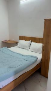 a bedroom with a bed with a wooden headboard at Hotel Aura Avenue in Bathinda