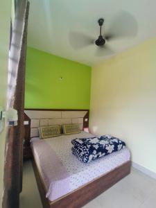 a bedroom with a bed with a green wall at Heera Hotel& Restaurant in Gupta Kāshi