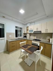 a kitchen with a table and two chairs and a table at Mina appartement in Ariana
