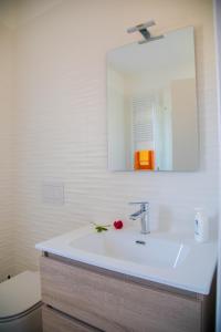 a bathroom with a white sink and a mirror at Umbra Living in Bastia Umbra +8 photos