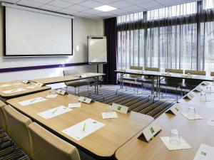 a conference room with tables and chairs and a screen at ibis Styles Lille Centre Gare Beffroi in Lille