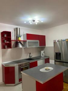 a kitchen with red cabinets and a stainless steel refrigerator at H&T in Senj