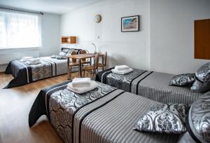 a hotel room with three beds and a table at VILLA DIANA USTKA to Twój wypoczynek, wyjątkowy klimat zapraszamy in Ustka