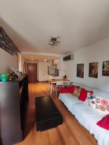 a living room with a white couch and a table at Pleno centro, 5 minutos Casco Vello, 400 metros estación AVE in Vigo