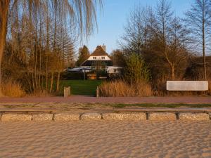 a bench in a park with a house in the background at Ferienwohnungen Dümmersee - Hexenhaus in Hüde