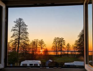 a view of a sunset from a window at Ferienwohnungen Dümmersee - Hexenhaus in Hüde +18 photos