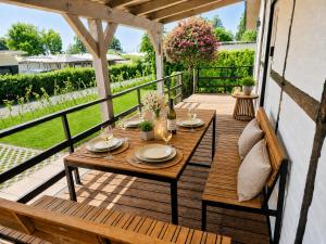 a wooden table on a deck with a view of a yard at Ferienwohnungen Dümmersee - Hexenhaus in Hüde