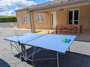 a ping pong table in front of a house at Villa Le Nid du Pont d'Arc in Vallon-Pont-dʼArc