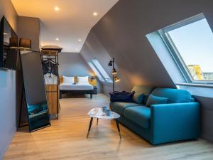 a living room with a blue couch and a window at ibis Paris La Villette Cité des Sciences 19ème in Paris +102 photos