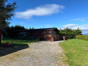 a house sitting on top of a gravel driveway at ballyskelly lodge in Jemimaville