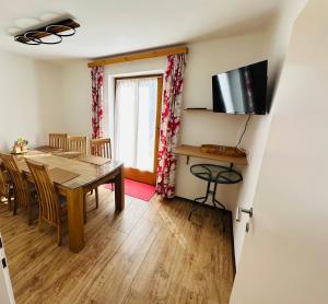 a dining room with a table and a television at Ferienhaus Ma-inz in Stadl an der Mur