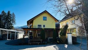a large yellow house with a porch at Ferienhaus Ma-inz in Stadl an der Mur
